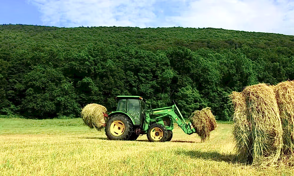 Tractor picking up hay